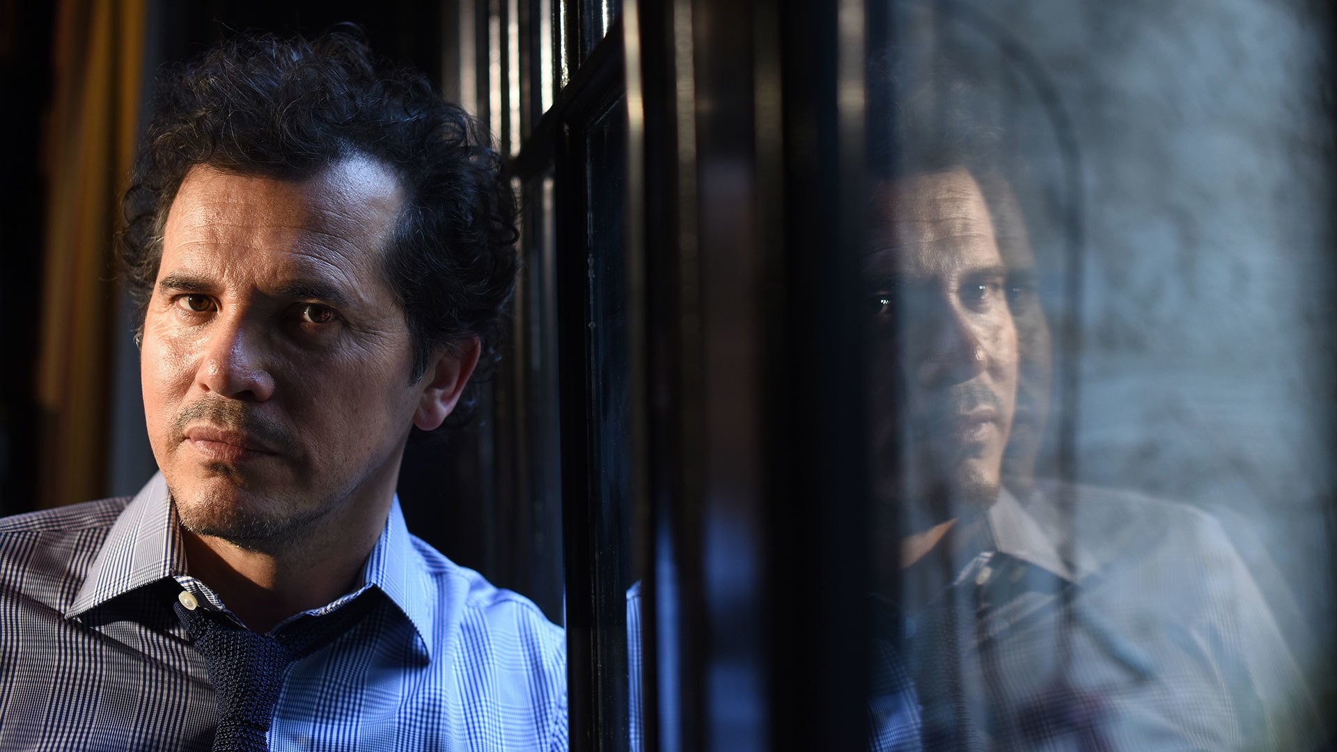 John Leguizamo at window